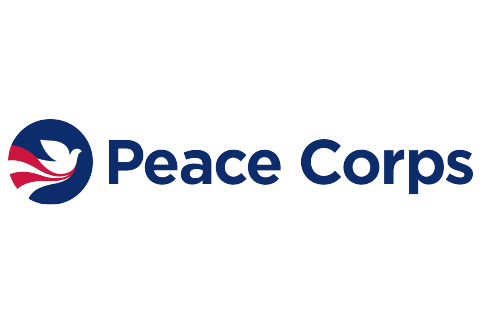 This is the logo for the United States Peace Corps. It is a blue circle with a white dove in the center. Underneath the dove, there are red and white stripes flowing under it. To the right of the circle are the words "Peace Corps."