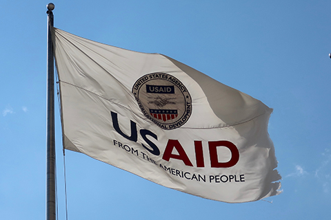 WASHINGTON - AUGUST 2, 2020: US AID Agency for International Development flag with emblem seal outside headquarters building. USAID is the agency that administers foreign aid.